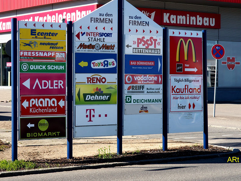 Wegweiser mit den relevanten Logos der Geschäfte